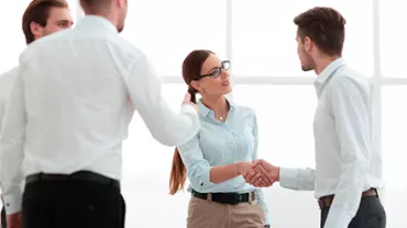 Personas de negocios dándose la mano en una reunión.